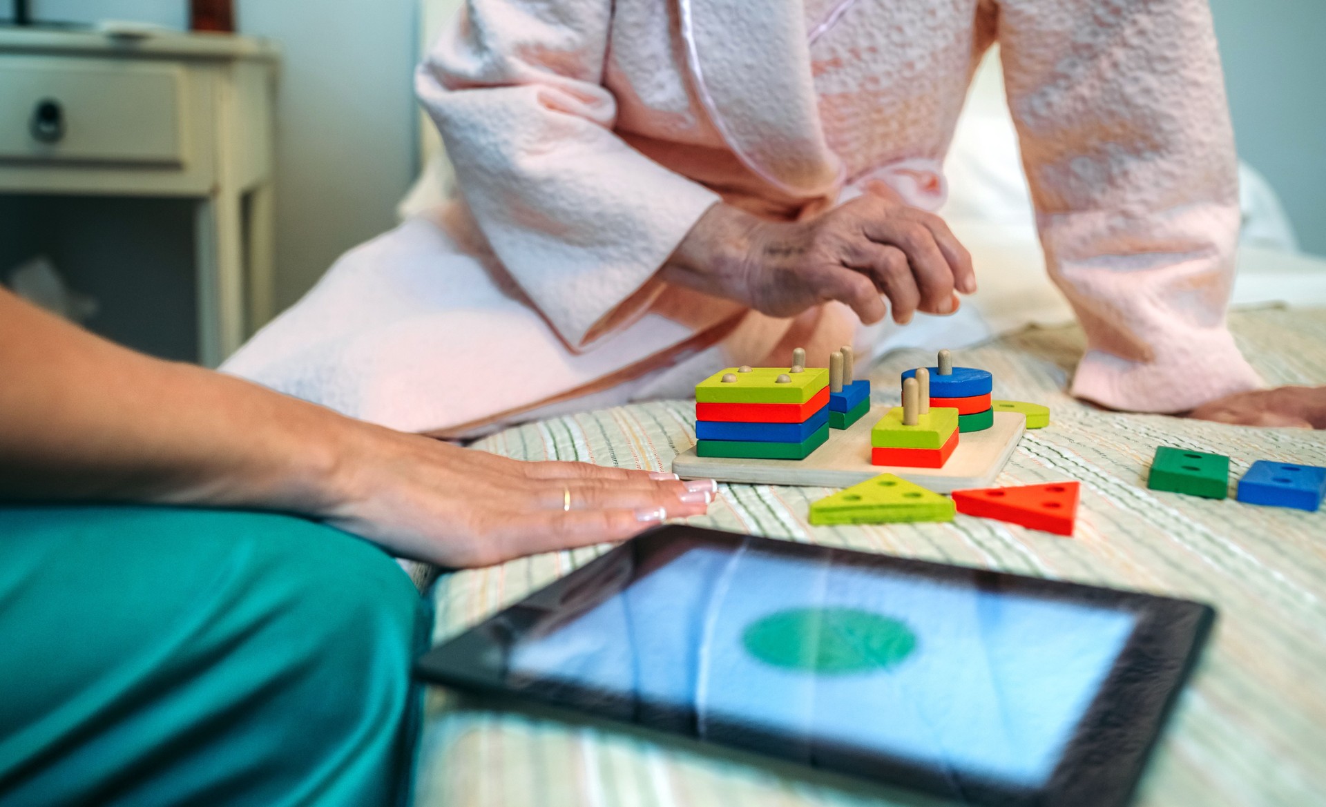 Female doctor showing geometric shapes to elderly patient